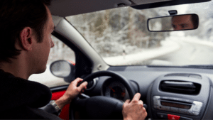 Man driving in winter weather looking out of windshield